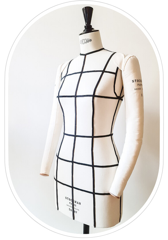 Cette image montre un mannequin de couture couvert de toile blanche, avec des bras rembourrés. Il est de trois quarts face. Des lignes noires matérialisent les lignes du patron : taille, poitrine, hanches, petites hanches, épaules, etc.